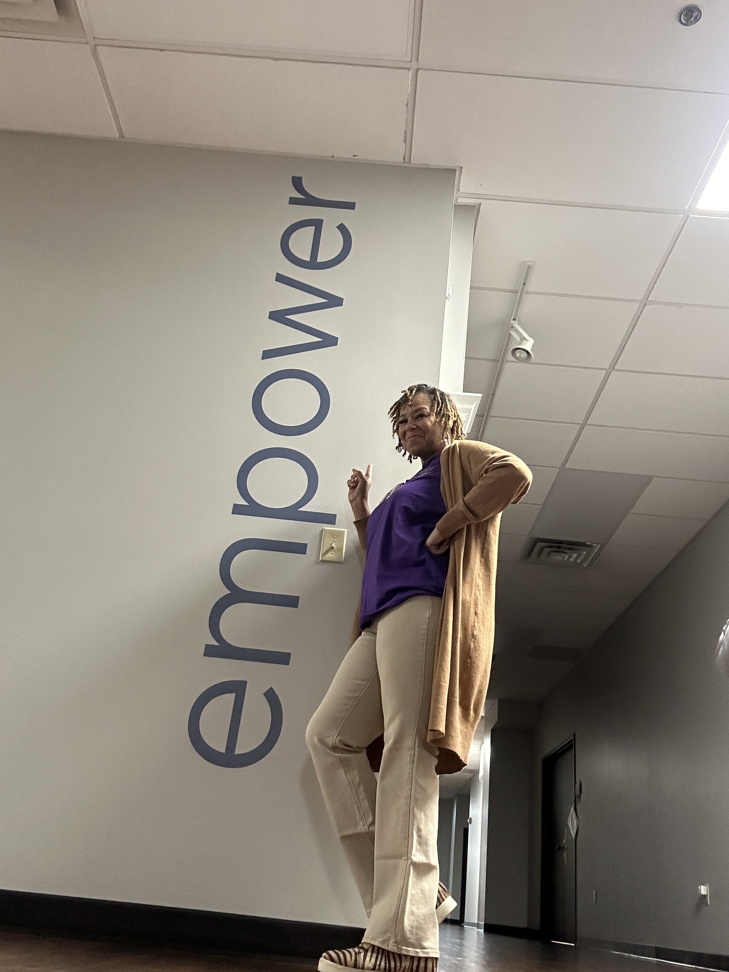 Shaunell posing in front of the word empower at Bosma Enterprises 